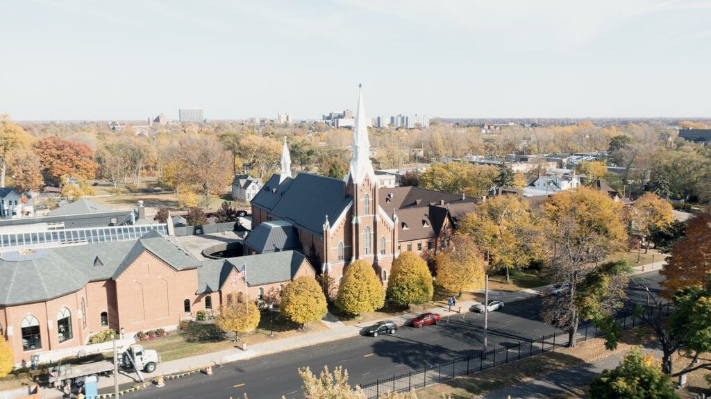 A landscape aerial photograph of the Mount Elliott Street façade of the Solanus Casey Center taken in October 2022 with the leaves changing color.